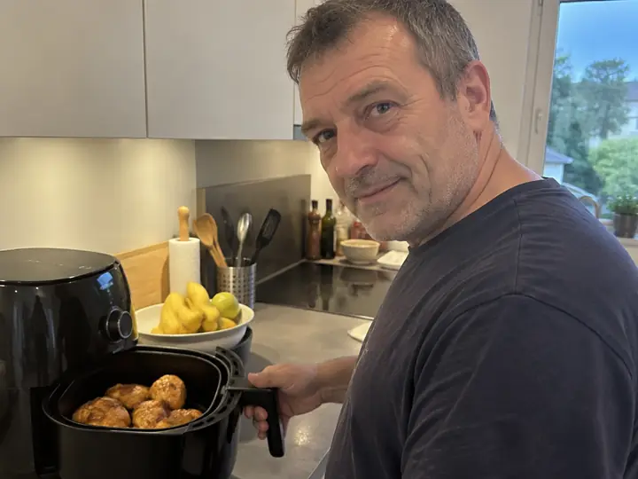 Personne préparant de la volaille au Air Fryer